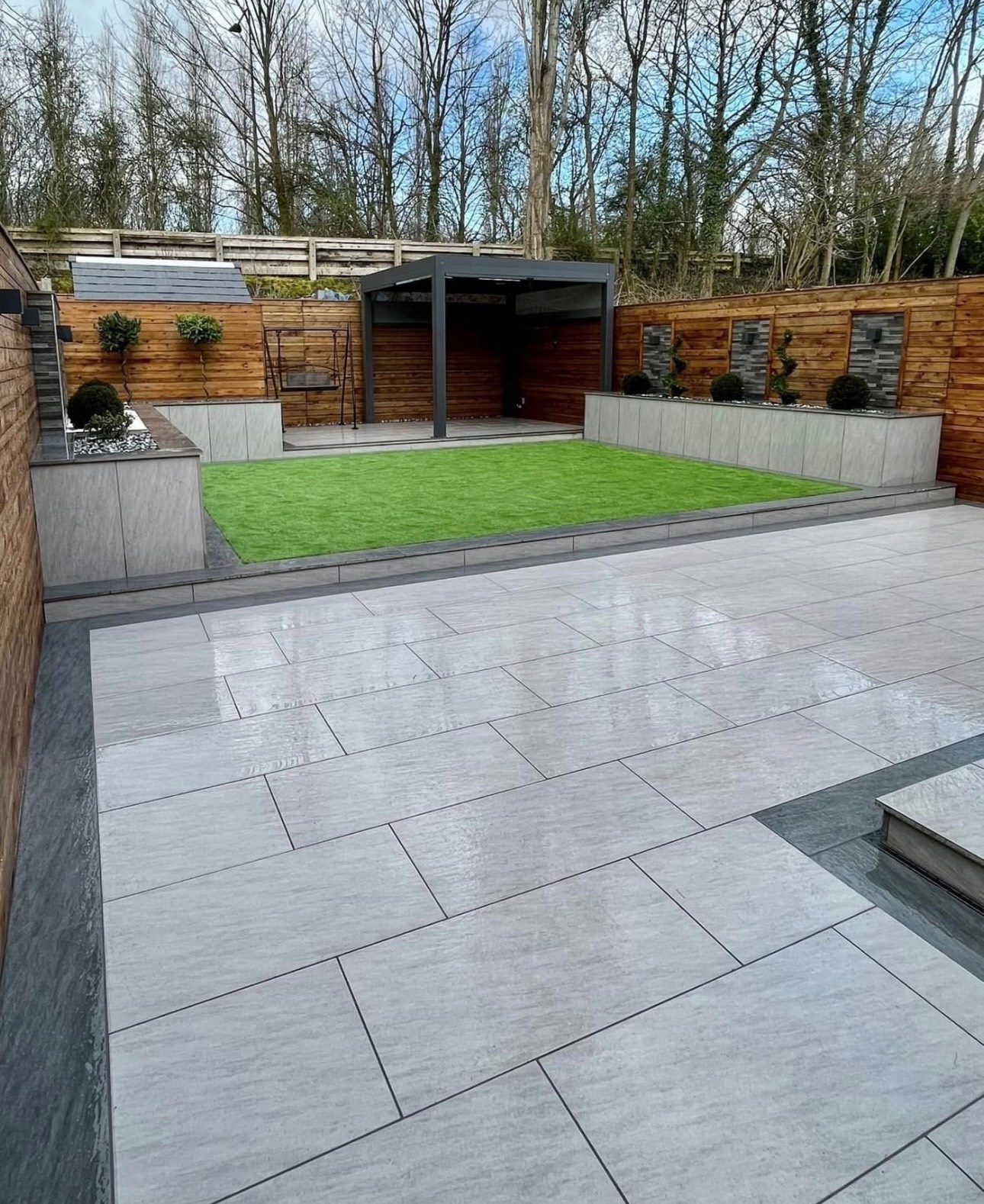Porcelain patio with raised beds and pergola